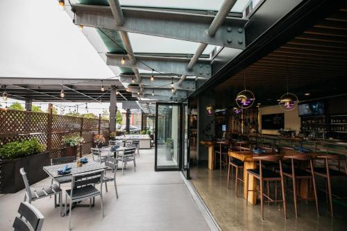 a restaurant with tables and chairs and a bar at Hotel Interurban Seattle Airport SeaTac in Tukwila