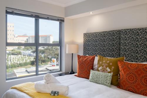 1 dormitorio con 1 cama y ventana grande en Paragon Artsy Home Vibes en Ciudad del Cabo