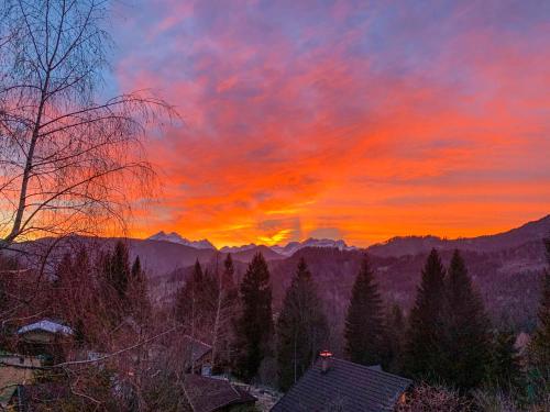 - un coucher de soleil dans les montagnes avec des maisons et des arbres dans l'établissement Dwarfs cabin overlooking Julian Alps near Bled, à Jesenice