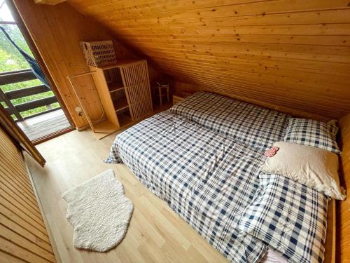 a room with a bed in a wooden cabin at Dwarfs cabin overlooking Julian Alps near Bled in Jesenice