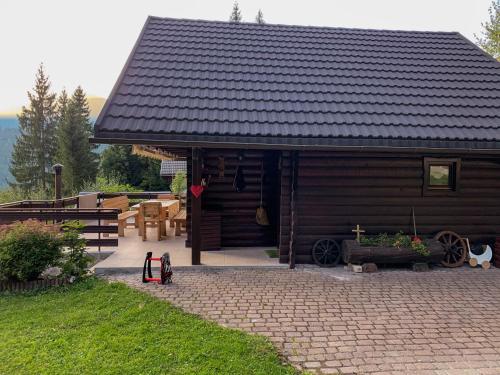 Ce chalet en bois dispose d'une terrasse, d'une table et d'un banc. dans l'établissement Dwarfs cabin overlooking Julian Alps near Bled, à Jesenice
