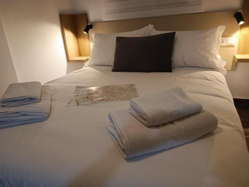 a white bed with two folded towels on it at ALOJAMIENTO VIVAL PINEDA in Baeza