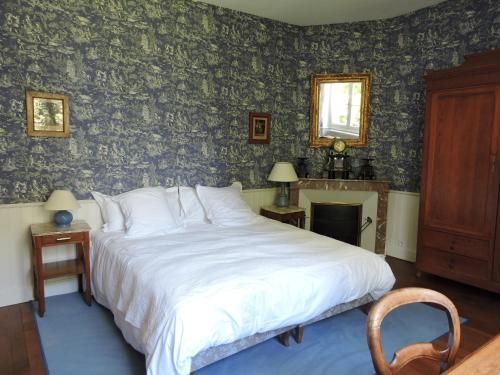 a bedroom with a bed and a wall with wallpaper at Le Domaine de Mestré, The Originals Relais in Fontevraud-l'Abbaye