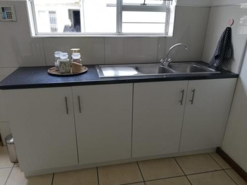 une cuisine avec un évier et un plan de travail dans l'établissement Rondebosch East Garlandale STRICTLY HALAAL, fresh garden cottage, au Cap