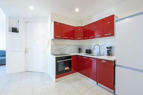 une cuisine avec des armoires rouges et un évier dans l'établissement VILLA VELLEDA, à Juan-les-Pins