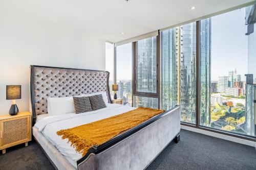 墨尔本Mega Style Apartments Epic的一间配有大床和大窗户的卧室