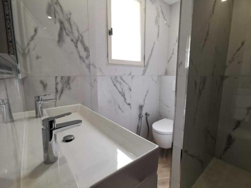 biała łazienka z umywalką i toaletą w obiekcie Bas de Villa au Calme w mieście Villeneuve-Loubet