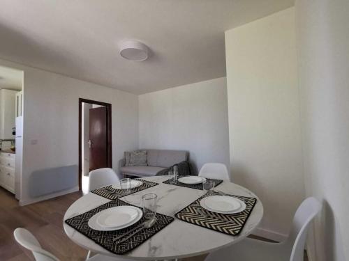 une salle à manger avec une table et des chaises blanches dans l'établissement Bas de Villa au Calme, à Villeneuve-Loubet