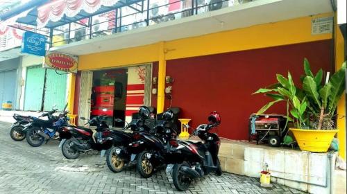 スマランにあるPringgondani Guesthouse Pandanaran Hillsの店外に停車する一連の二輪車