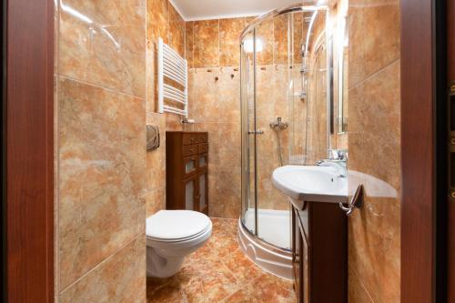 uma casa de banho com um WC, um chuveiro e um lavatório. em ANKER em Kolobrzeg