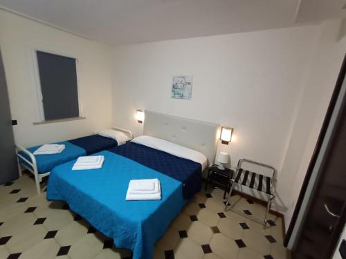 una stanza con due letti e una sedia di Hotel La Torre a Cervia