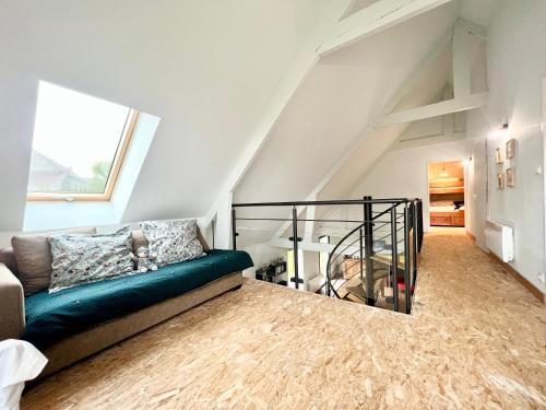 ein Wohnzimmer mit einer grünen Couch im Dachgeschoss in der Unterkunft COC - Le Gulistan in Wissant