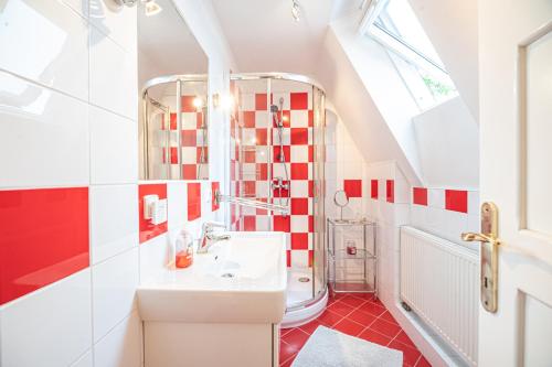 a red and white bathroom with a sink and a toilet at Vila Lumír in Poděbrady