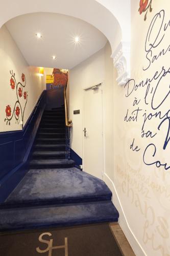 a hallway with a staircase with a mural on the wall at Hôtel St Sernin in Toulouse