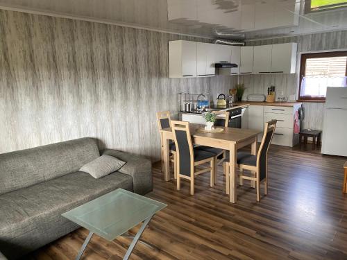 uma sala de estar com um sofá, uma mesa e uma cozinha em Domek letniskowy nad jeziorem w Stęszewku em Stęszewko