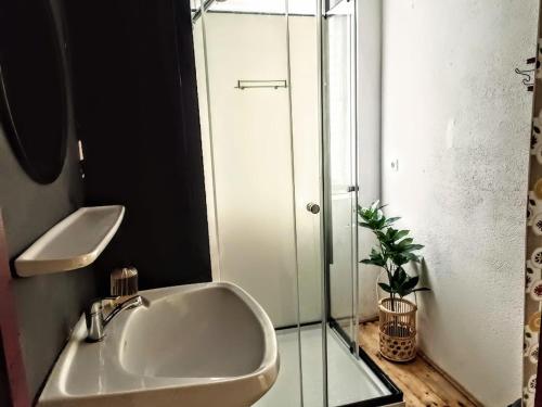 a bathroom with a sink and a glass shower at Lounge-Style-Hostel in Sankt Veit an der Glan