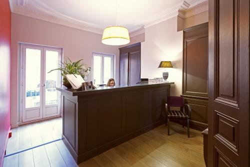 a woman sitting at a bar in a room at Hôtel St Sernin in Toulouse