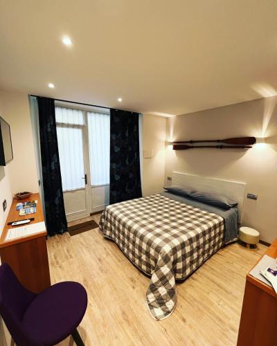 a bedroom with a bed and a chair in it at Wowies room in Pettenasco