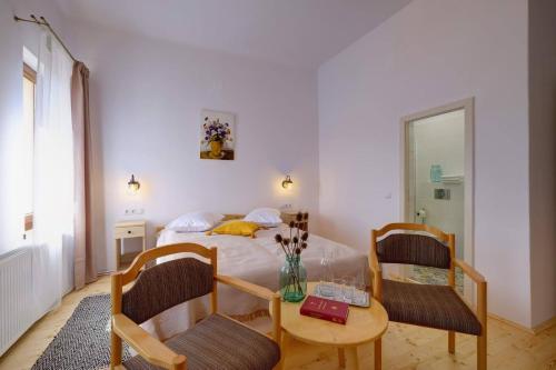 a bedroom with a bed and a table and chairs at Elimheim in Cisnadioara