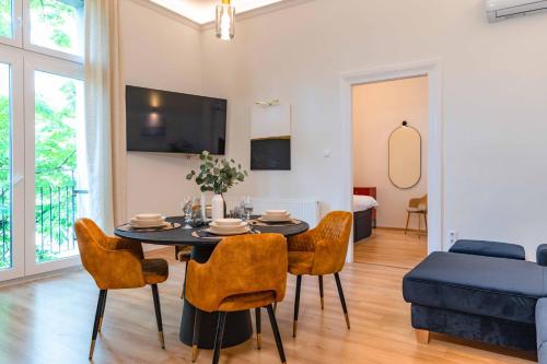 uma sala de estar com mesa e cadeiras em Modern Apartment French Balkony em Budapeste