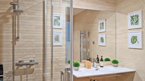 y baño con lavabo y ducha. en Mood Bilbao Apartamentos - New & Special en Bilbao