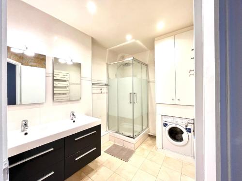 une salle de bain avec un lavabo et une machine à laver dans l'établissement Cosy appartment in the marais district, à Paris