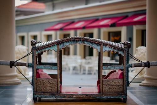 a chair with pink cushions in a room at Raajkutir - IHCL SeleQtions in Kolkata