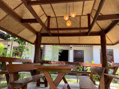 a wooden picnic table under a roof with a chandelier at Hotel Pailifornia in Pai