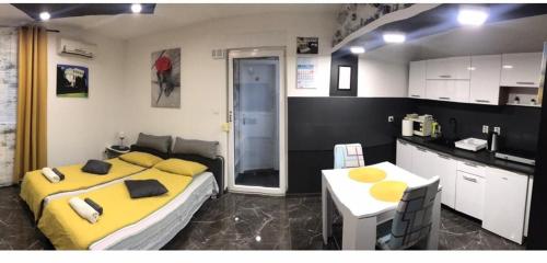 een slaapkamer met een geel bed en een keuken bij Studio DAMA blizina amfiteatra i bus kolodvora ,privatan parking ,Self-Check- In in Pula