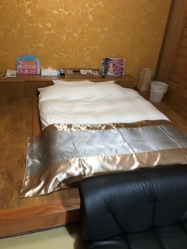 Ōnoにある宮島プリンセスの革張りの椅子が備わる部屋のベッド1台