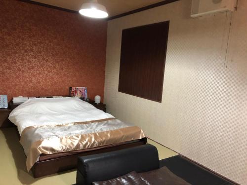 a bedroom with a bed and a chair in it at 宮島プリンセス in Ōno
