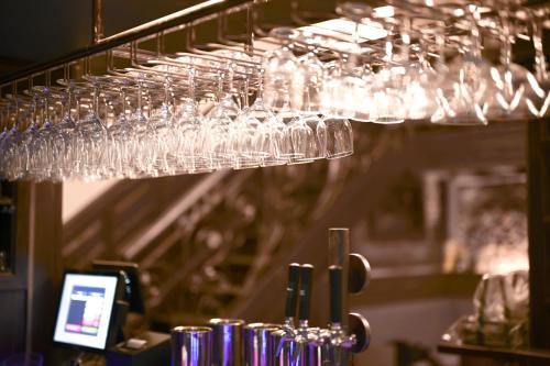 une bande de verres à vin suspendus à un portant dans l'établissement Old Town Stay Hostel, à Stockholm