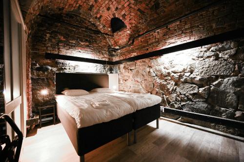 een slaapkamer met een bakstenen muur en een bed erin bij Old Town Stay Hostel in Stockholm