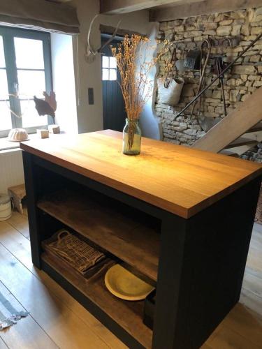 a wooden table with a vase on top of it at Petite maison d'Amelotte in Sainte-Cécile