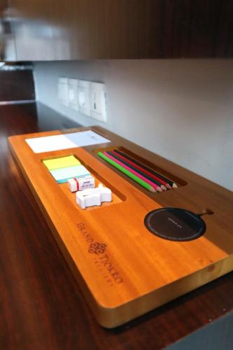 a wooden table with pens and markers on top of it at Grand Tjokro Premiere Bandung in Bandung