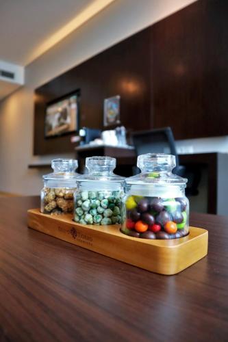 a display of fruits and vegetables in glass jars on a table at Grand Tjokro Premiere Bandung in Bandung