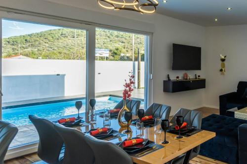 une salle à manger avec une table et des chaises et une piscine dans l'établissement Luxury Villa Impossible, à Trogir