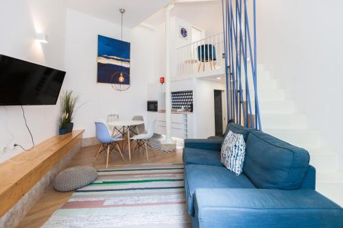 un soggiorno con divano blu e tavolo di FLH Graça Lovely Apartment II a Lisbona