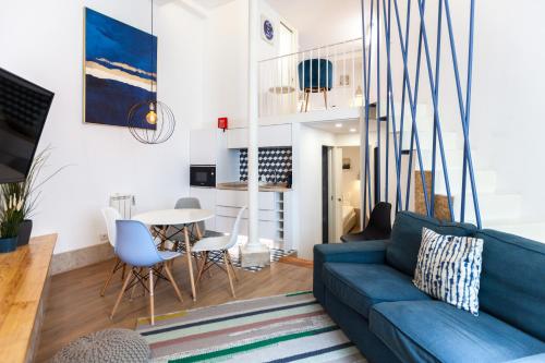 un soggiorno con divano blu e tavolo di FLH Graça Lovely Apartment II a Lisbona