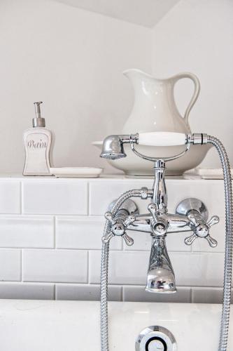 La salle de bains est pourvue d'un lavabo et d'un robinet. dans l'établissement D'un jour à l'autre, à Banassac