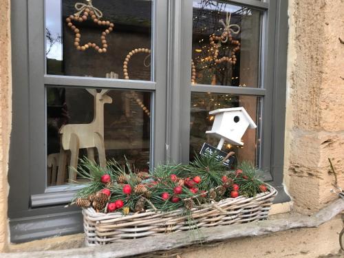 a window sill with a basket of christmas decorations at Petite maison d'Amelotte in Sainte-Cécile