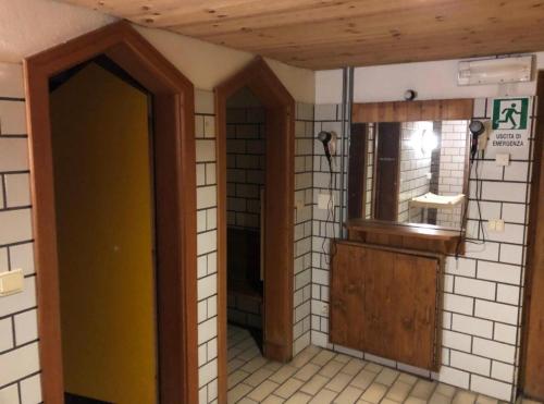 een badkamer met een gele deur in een kamer bij Mansarda Élite Villaggio Ploner in Dobbiaco