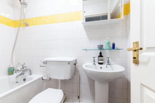 a white bathroom with a toilet and a sink at Elegant Art Deco whole apartment 2mins to Hyde Park, 8mins to Bayswater, Nottinghill, Paddington in London