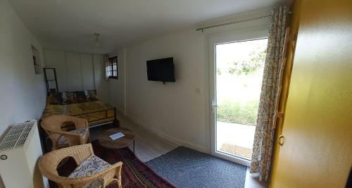 Cette chambre dispose d'une télévision et d'une porte coulissante en verre. dans l'établissement Au Dolmen, à Brantôme