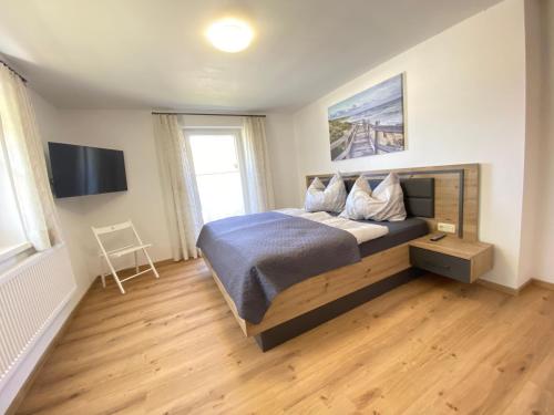 ein Schlafzimmer mit einem großen Bett und einem TV in der Unterkunft Ferienhaus Mayr in Bad Aussee