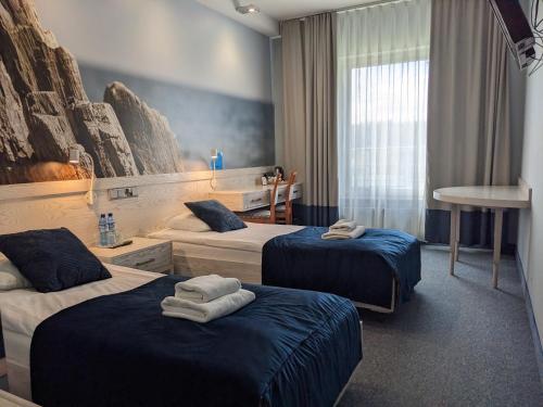een hotelkamer met 2 bedden en handdoeken erop bij Hotel Morski in Gdynia