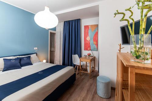 a hotel room with a bed and a desk at Neocore in Naples