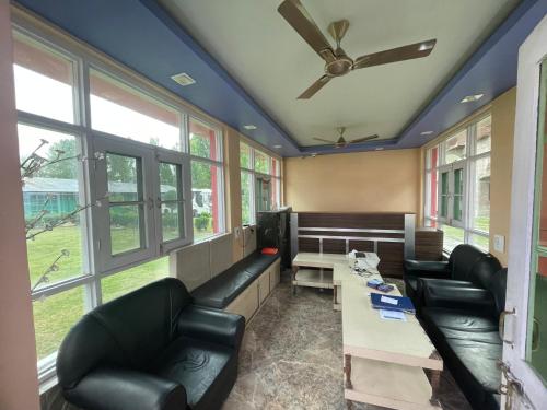 - une salle d'attente avec canapés, télévision et fenêtres dans l'établissement hotel new sahil, à Srinagar
