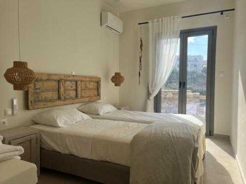 a bedroom with a large bed and a window at Deja Blue Villa 1 in Agios Georgios