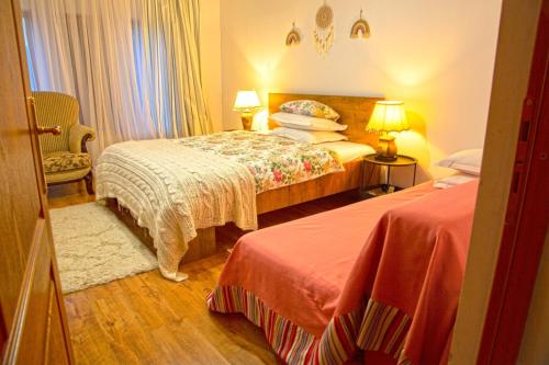 1 Schlafzimmer mit 2 Betten und 2 Lampen in der Unterkunft Casuta-Lacului in Unciuc